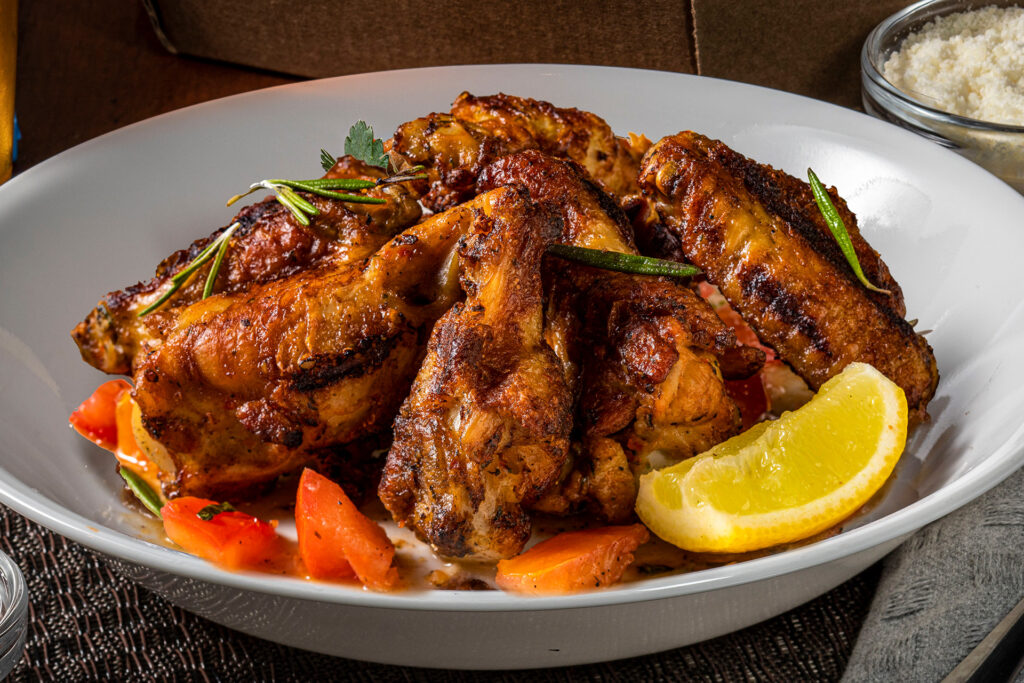 6 Grilled Tuscan Wings on a white plate with a lemon slice